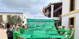 La AECC celebra la tradicional cuestación en la plaza de la Constitución de Formentera Despliegue bandera AECC en la plaza de la Constitución