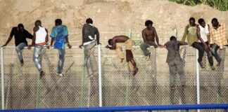El problema Migrants enfilats sobre una tanca